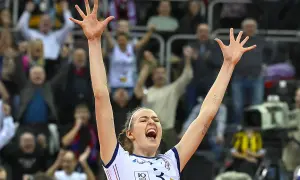 Karolina Drużkowska z uniesionymi rękami, krzyczy z radości na meczu siatkówki.