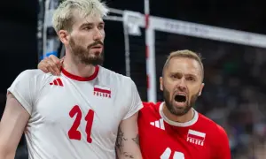 Paweł Zatorski, siatkarz w białej koszulce z numerem 21, otrzymuje wsparcie od kolegi z drużyny w czerwonej koszulce.