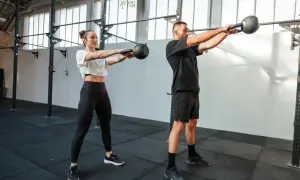 Para dowodowy na siłowni wykonuje ćwiczenie z kettlebell. To właśnie crossfit co to za trening?
