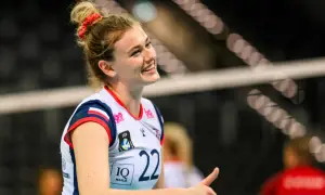 Uśmiechnięta siatkarka Natalia Lijewska w białej koszulce z numerem 22, z czerwoną opaską na włosach, podczas meczu.