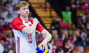 Młody siatkarz Jakub Kochanowski, numer 15, w biało-czerwonej koszulce reprezentacji Polski, z piłką w dłoni. Jego wzrost robi wrażenie.