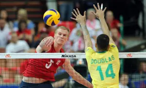Kyle Russell z USA atakuje piłkę do siatkówki, blokowany przez Douglasa z Brazylii.