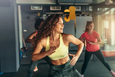 Kobiety tańczące w rytm muzyki na zajęciach zumba. To świetny sposób na aktywność fizyczną i dobrą zabawę.