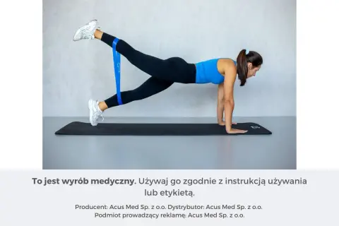 Kobieta ćwiczy z taśmą oporową, unosząc nogę. To może pomóc w walce z zakwasami.