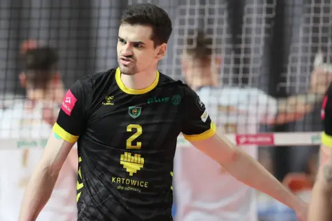 Szymański siatkarz w czarnej koszulce z numerem 2, zdeterminowany na boisku.