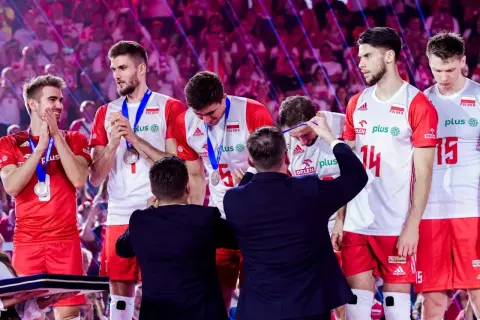 Polscy siatkarze odbierają medale po Mistrzostwach Europy. Duma i radość na twarzach zawodników.