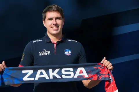 Tomasz Kalembka w koszulce ZAKSA trzyma szalik z napisem ZAKSA.