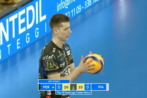 Siatkarz z piłką w rękach podczas meczu włoskiej ligi siatkówki. Wynik 26:25 dla PER.