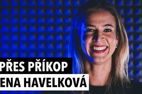 Uśmiechnięta Helena Havelková na tle niebieskiej, akustycznej ściany. Napis "PŘES PŘÍKOP ENA HAVELKOVÁ" sugeruje jej obecność w jakimś projekcie.