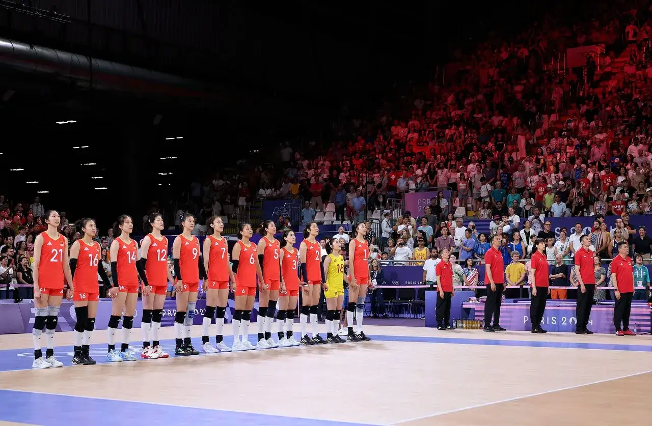 Chińska drużyna siatkarska w czerwonych strojach podczas Igrzysk Olimpijskich, gotowa do rywalizacji.