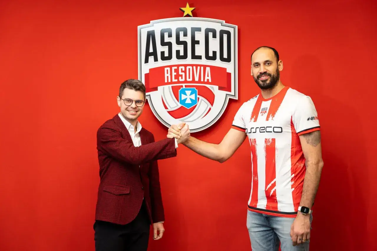 Mauricio Borges i przedstawiciel Asseco Resovii ściskają sobie dłonie przed logo klubu.