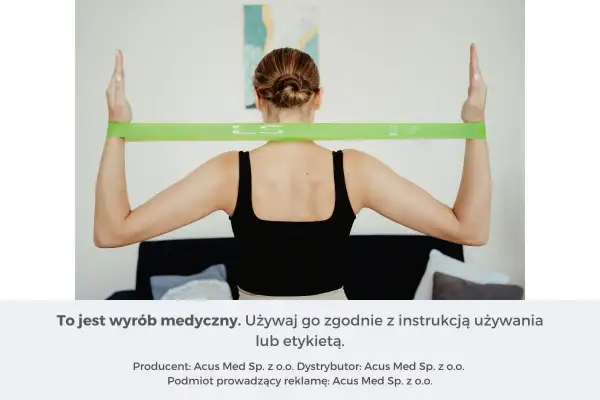 Kobieta ćwiczy z zieloną gumą, która jest idealna do rehabilitacji i wzmacniania mięśni. Jakie gumy do ćwiczeń wybrać?